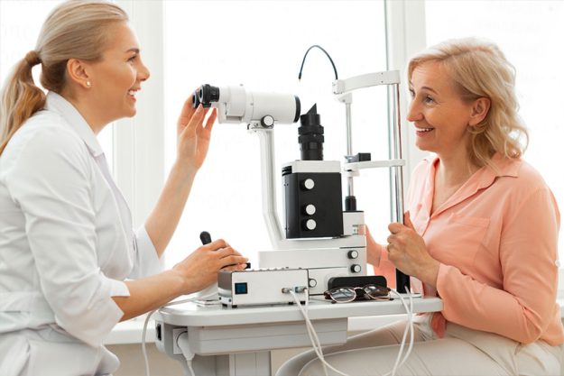 Smiling good-looking oculist with tied hair having pleasant appointment