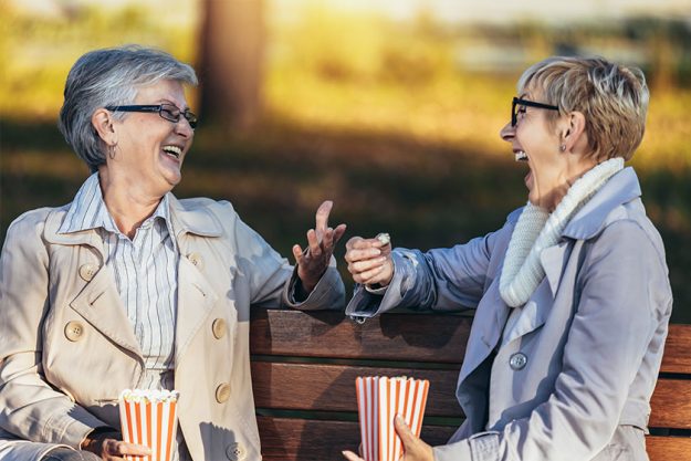 Two Senior Female Friends Sitting Bench Park
