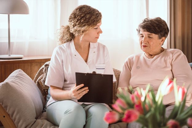 Young nurse helping elderly lady with filling in the forms Young nurse helping elderly lady with filling in the forms