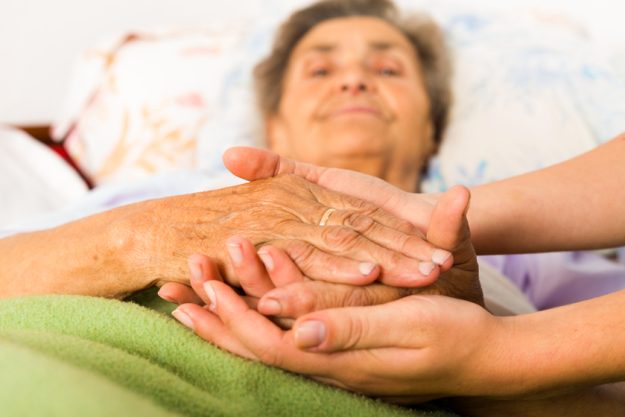 Caring Nurse Holding Hands Bad Behaviors in Dementia Patients: Here's How Our Staff In Memory Care Facilities In Lutz, FL Can Handle