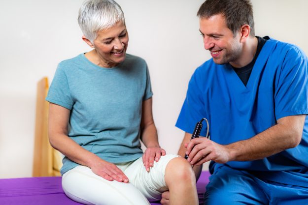 Laser Physical Therapy. Physical Therapist Treating Senior Woman’s Knee Finding A Safe Place For Your Loved Ones With Osteoporosis: X Reasons Why Assisted Living In San Antonio, TX Is The Right Option