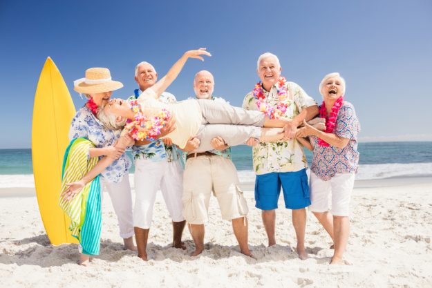 Senior friends holding senior woman on the beach How To Embrace 55+ Communities Near Delray Beach, FL