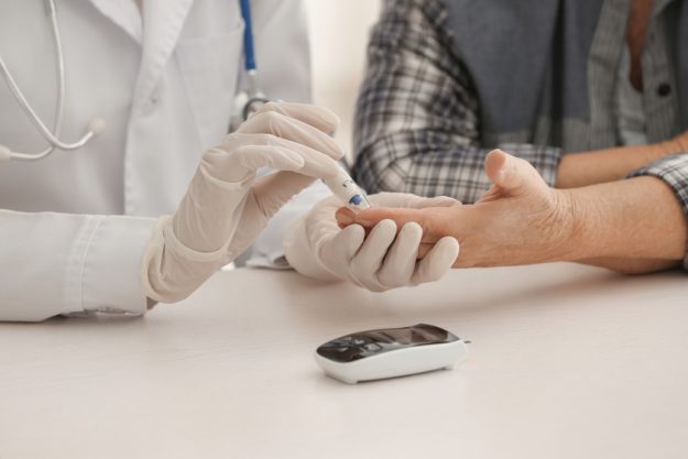 Doctor measuring blood sugar level of diabetic patient in clinic, closeup What You Should Ask When Selecting A Senior Living Community In Florida For Your Loved One With Diabetes