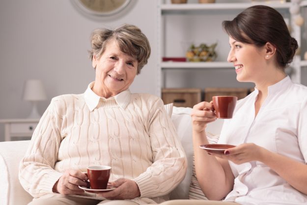 Drinking tea together Aged smiling woman