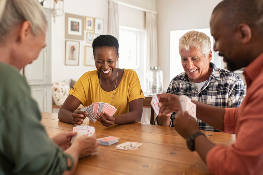 Mature friends playing cards at home X Things To Look For When Searching For The Best Senior Living Community In Florida For Your Loved One Who's Struggling With Addiction