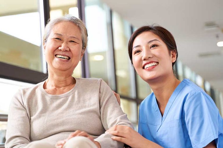 Asian senior woman and her caregiver looking