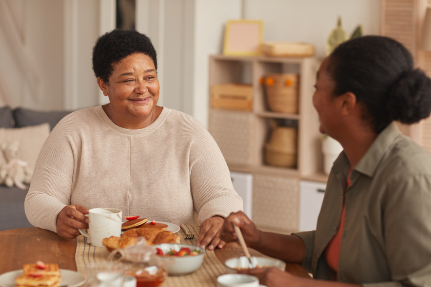Senior African-American Woman Enjoying Breakfast with Daughter Cutting Food Costs When Aging At Senior Living Residences In Bonita Springs, FL