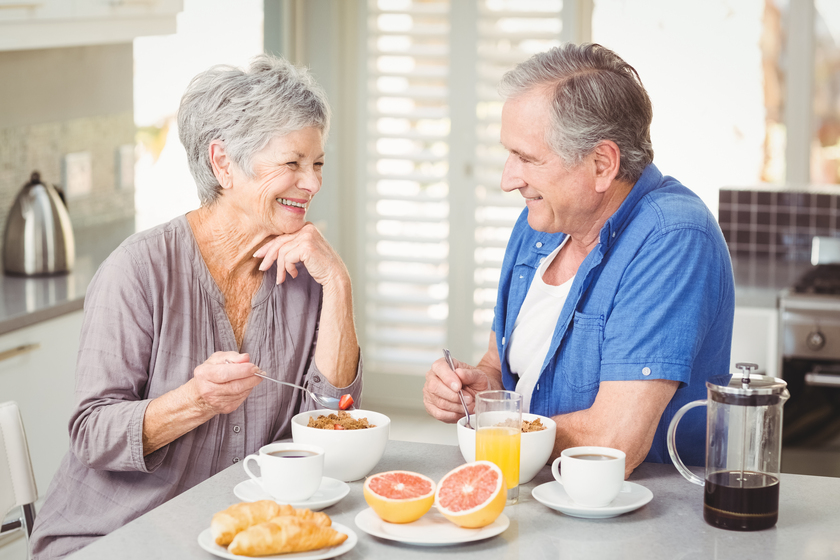 Happy senior couple discussing while having breakfast at table Healthy Eating Changes You Should Make While Staying In An Assisted Living Apartment In Naples, FL
