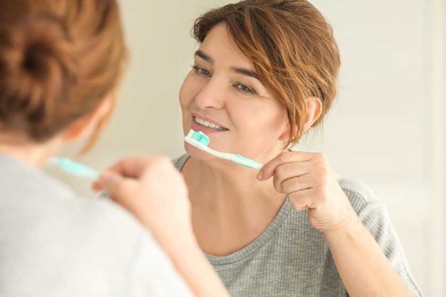 Senior woman cleaning teeth Senior woman cleaning teeth