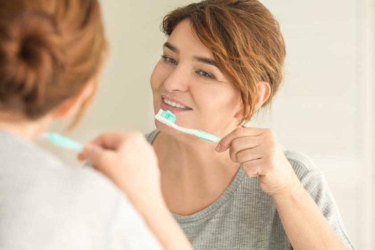 Senior woman cleaning teeth