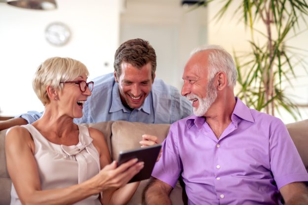 Family enjoying at home 6 Ways Assisted Living Helps Protect Seniors From Funeral Scams