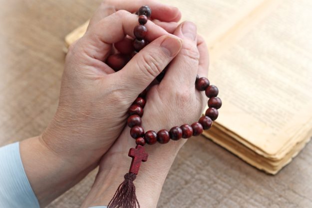 Woman’s hands holding rosary, close-up Woman's hands holding rosary, close-up