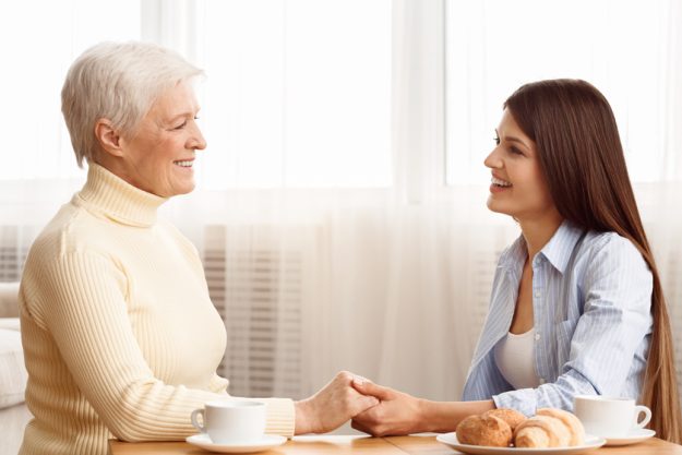 Care and support. Daughter holding mother's hand