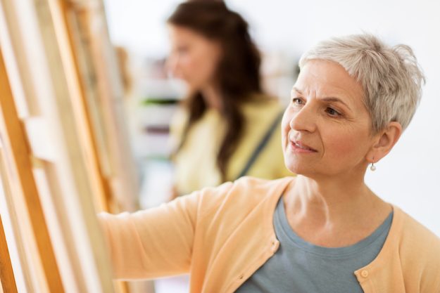 woman artist with easel drawing at art school woman artist with easel drawing at art school