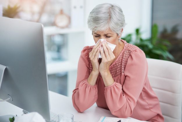 Sick days at the office are the worst. a mature businesswoman blowing her nose while sitting at her office desk at work. Sick days at the office are the worst. a mature businesswoman blowing her nose while sitting at her office desk at work.