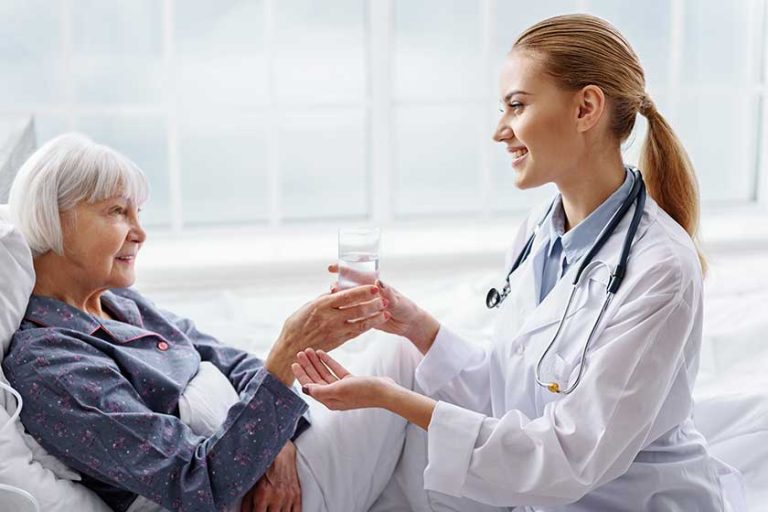 Cheerful practitioner keeping out glass of water