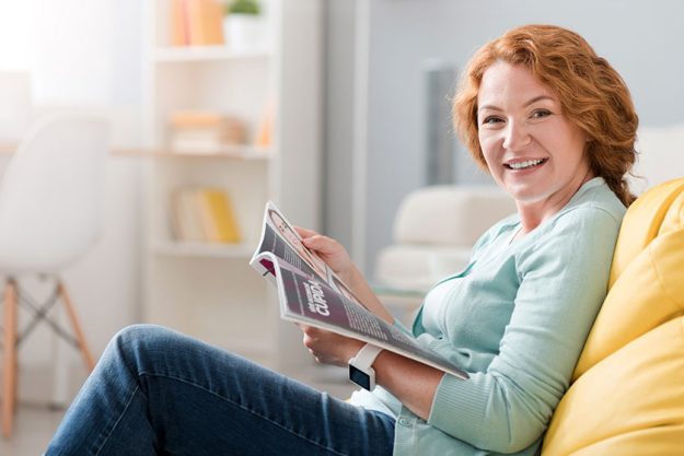 Cheerful senior woman sitting on the couch Cheerful senior woman sitting on the couch