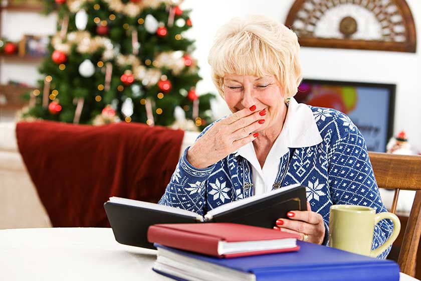 Christmas: Senior Woman Looks At Photo Albums