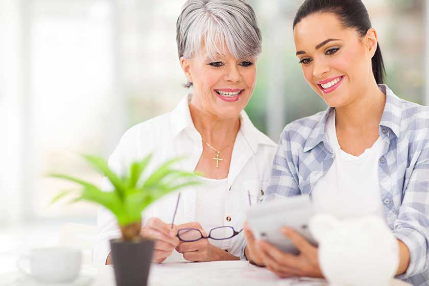 Daughter helping middle aged mother calculate