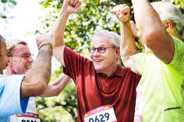 Group of cheerful senior runners at the park