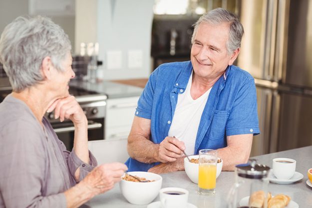 Happy senior couple talking while having breakfast Happy senior couple talking while having breakfast