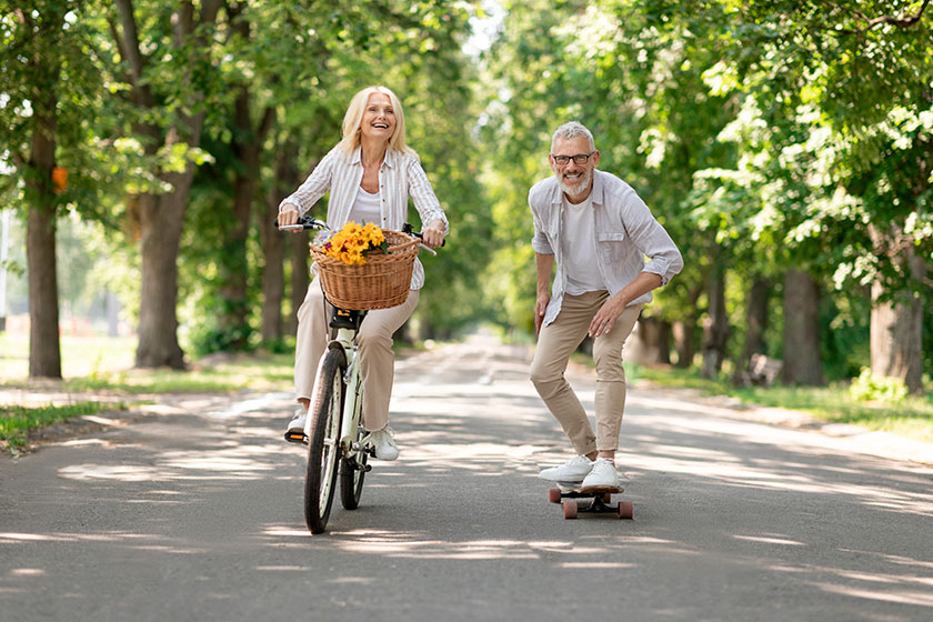 Modern Pensioners. Happy Senior Couple Riding Bike