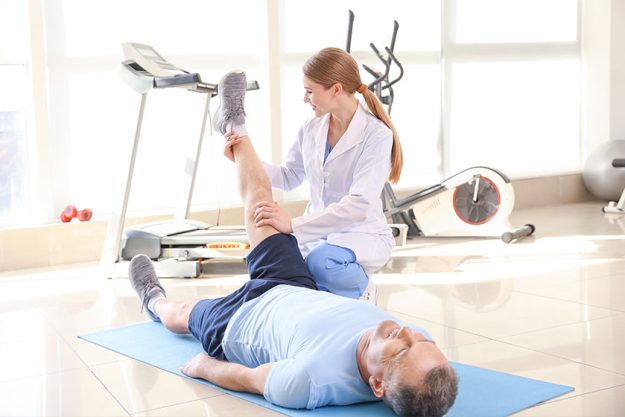Physiotherapist working with mature patient Physiotherapist working with mature patient