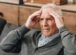 Retired man with grey hair having headache