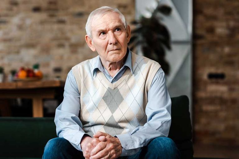 Sad elderly man sitting on sofa during self isolation Sad elderly man sitting on sofa during self isolation