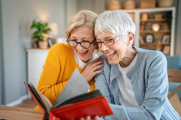 Senior mature women friends or sisters looking family photos