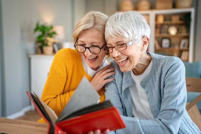 Senior mature women friends or sisters looking family photos Senior mature women friends or sisters looking family photos