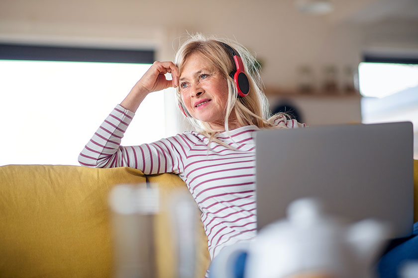 Senior woman with headphones and laptop
