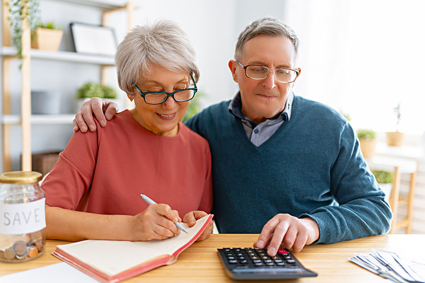 Elderly married couple sitting at the desk