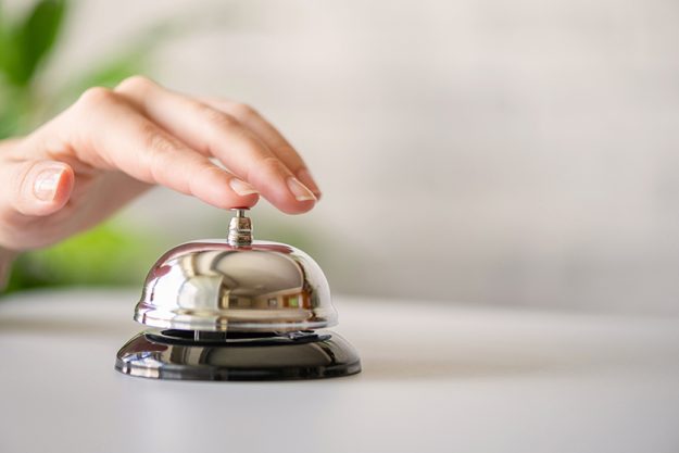 Hand of guest ringing in silver bell