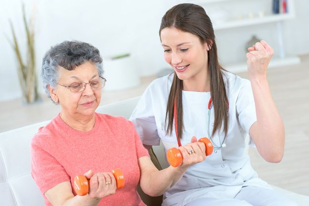 Helping senior woman work out