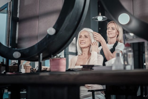 Joyful positive woman looking at her reflection Joyful positive woman looking at her reflection