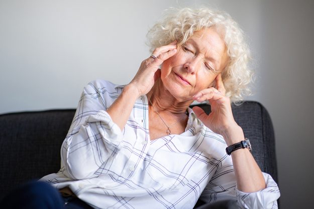 Portrait elderly woman sitting on sofa