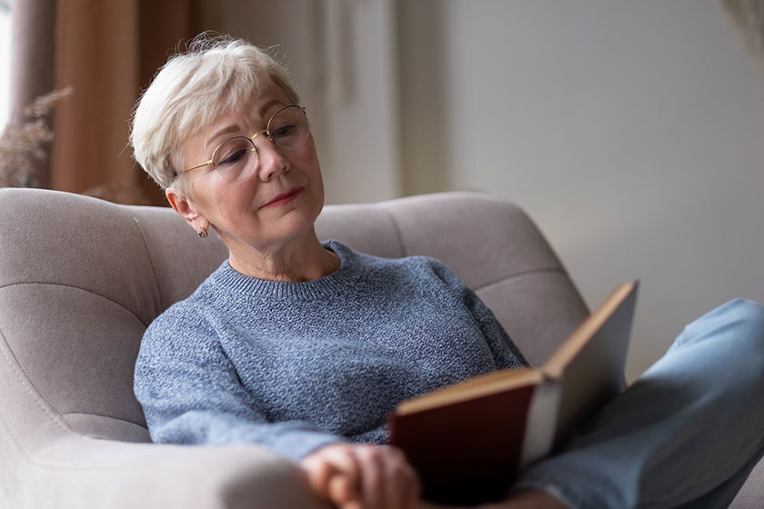 Senior caucasian woman at home reading book