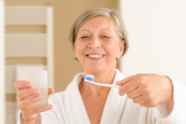 Senior woman hold toothbrush and glass water Senior woman hold toothbrush and glass water