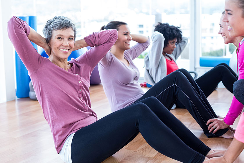 Woman doing sit ups with friends