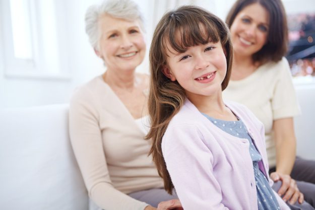 Family is like a glimpse of heaven. Portrait of an adorable little girl with her mother and grandmother in the background.