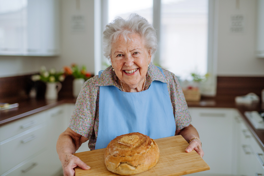 Portrait of senior woman with fresh baked bread. Portrait of senior woman with fresh baked bread.