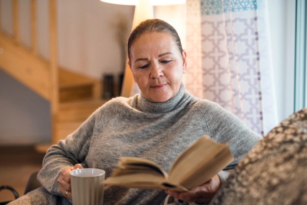 Portrait of senior woman sitting on sofa indoors at home, reading book. Portrait of senior woman sitting on sofa indoors at home, reading book.
