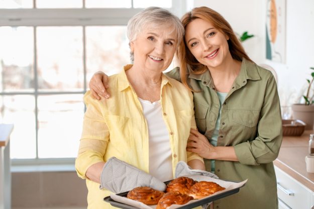 Mature woman with her mother cooking together at home