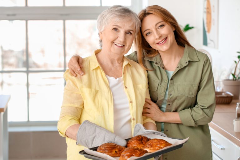 Mature woman with her mother cooking together at home