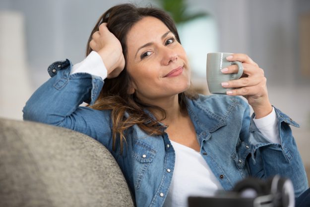 enchanting european girl drinking tea on sofa enchanting european girl drinking tea on sofa