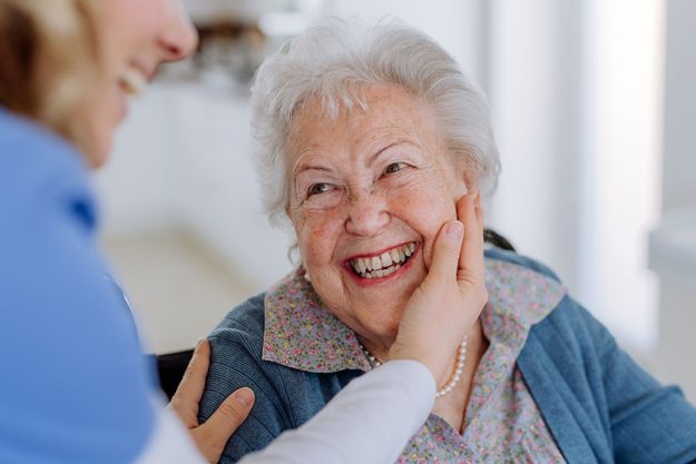 Close up of a nurse stroking cheek of senior woman Close up of a nurse stroking cheek of senior woman