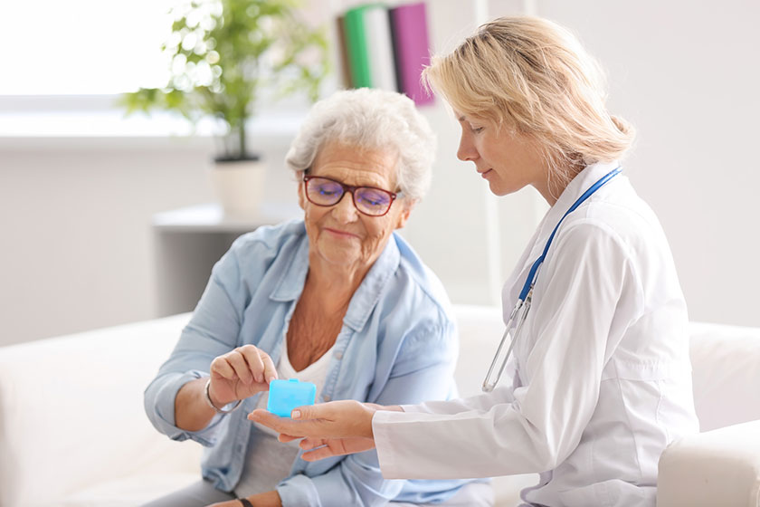 Doctor giving medicine to senior woman at home Doctor giving medicine to senior woman at home