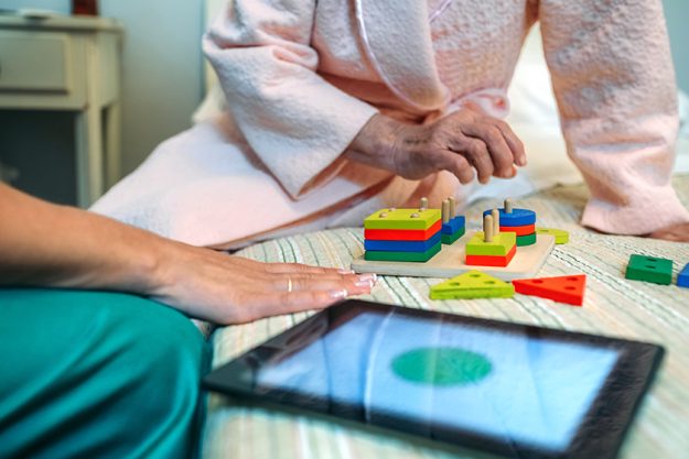 Female doctor showing geometric shapes to elderly patient
