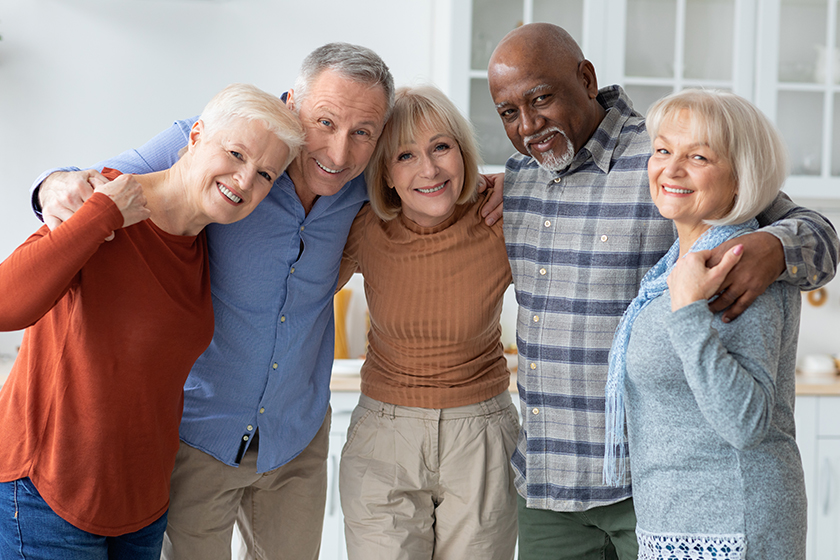 Group photo of happy elderly people hugging, smiling at camera Group photo of happy elderly people hugging, smiling at camera